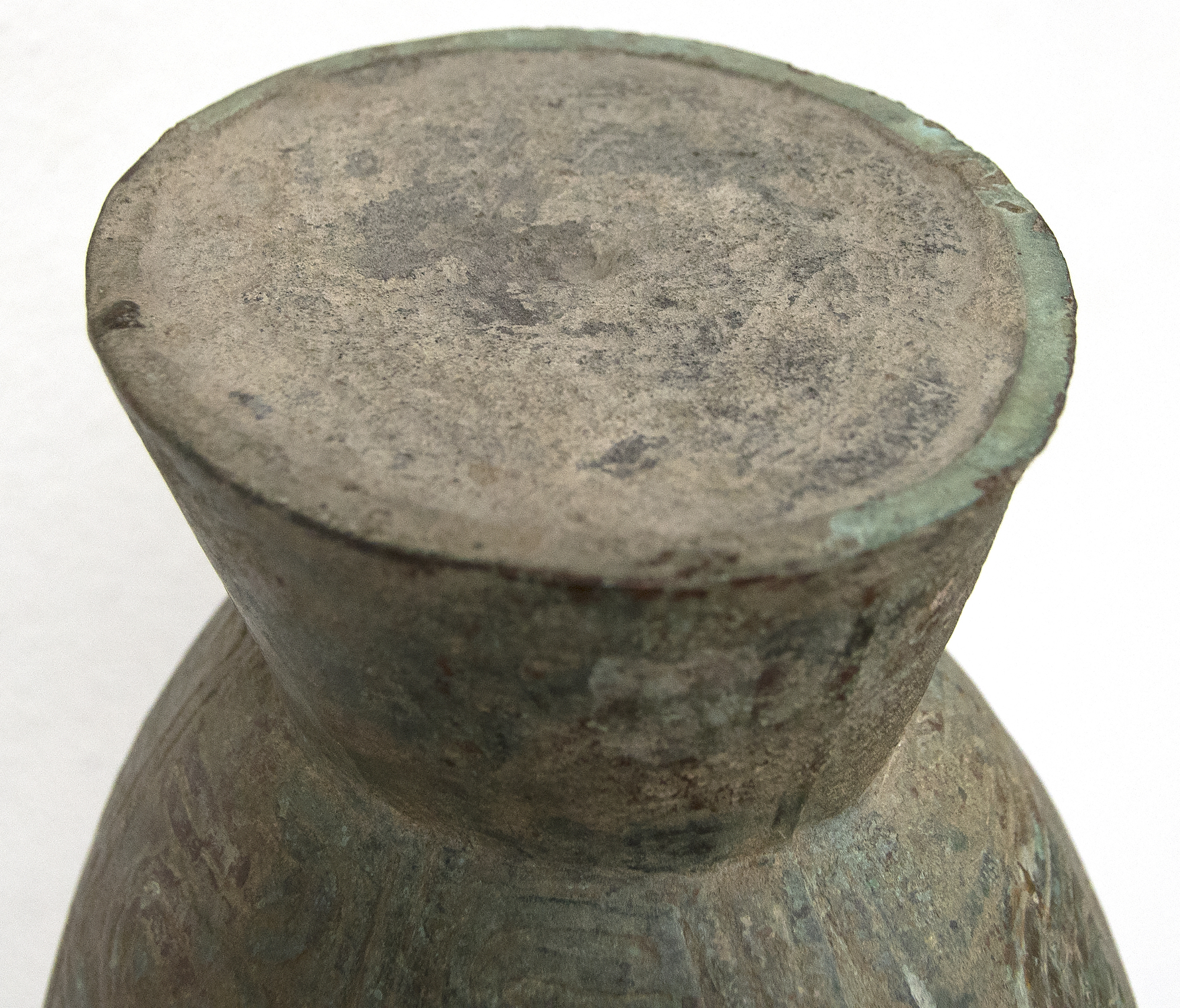 This well preserved bell is one of the largest known bronzes from the Southeast Asian Bronze Age, generally named after the Dongson site in North Vietnam.  The swirling band design is finely and crisply cast. Dongson bronze drums were also reported in South China, Thailand, Laos, West Malaysia, and Indonesia and as Far East as Western Iranian Java. 
<br>
<br>The Dong Son culture is a Bronze age culture including all of southeast Asia and into the Indo-Malaya Archipelago from about 1000 to 1 BC. Centered on the Red River Valley of Vietnam, the Dong Son were sophisticated agriculturalists, raising rice and buffalo. Dong Son probably arose from local Neolithic cultures, such as Phung Nguyen and Dong Dau phases. Dong Son is identified with the Van Lang ruling dynasty, the first ruling dynasty of Vietnam. By the second century BC, impacts from the Han Dynasty in China were being felt and according to historic records, the Dong Son were absorbed into the Han Dynasty territory.