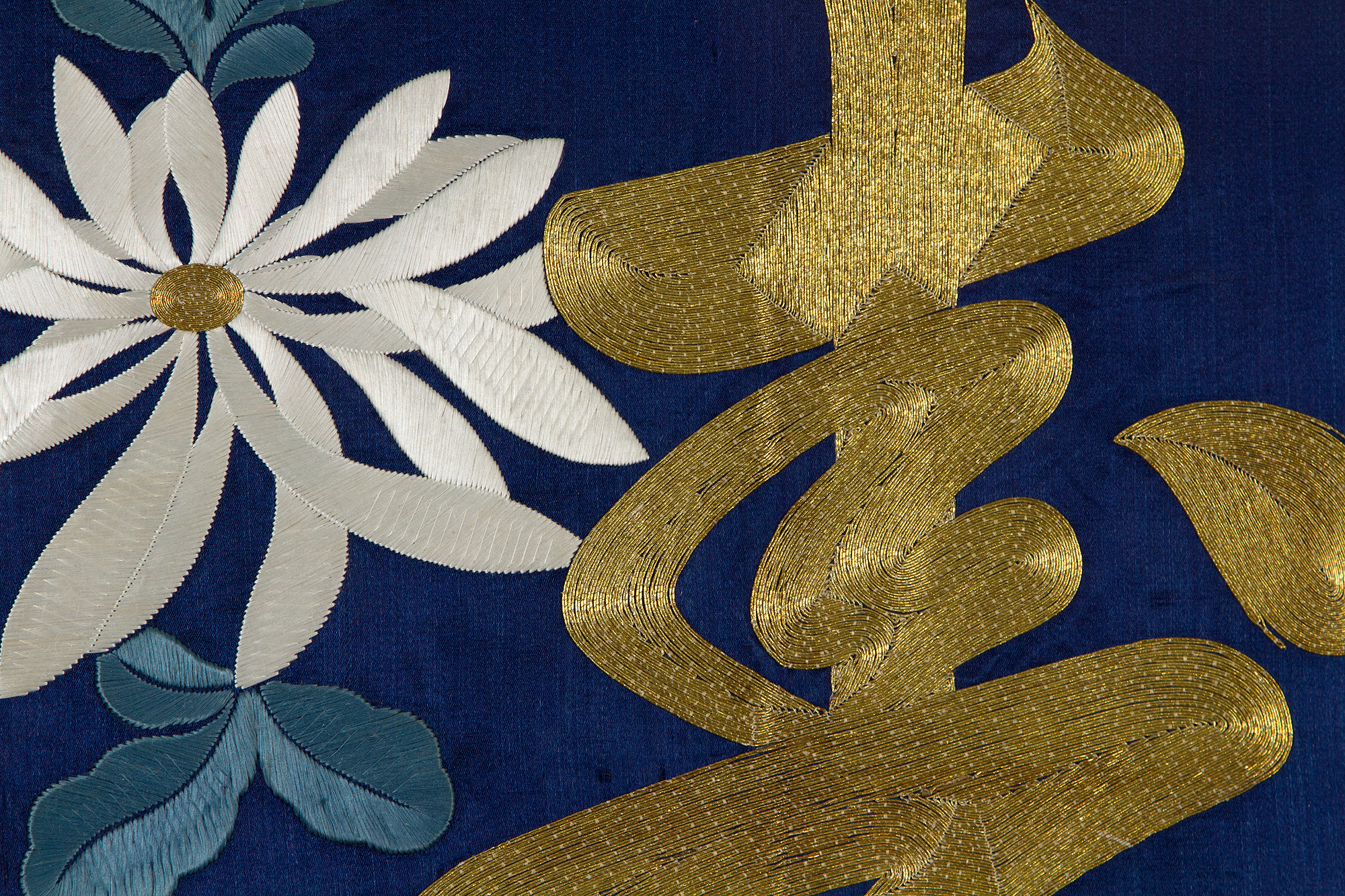 The character shown here is the character for long life, read shou in Chinese and kotobuki in Japanese. The elegance of the characters, especially when depicted in their cursive forms, has made them poplar decorative motifs on textiles, ceramics, lacquer and many other media. Here the character, built up using gold-wrapped threads, is surrounded by chrysanthemums, which are also symbols of long-life because of their health-giving properties. Such a fukusa was likely made as a cover for a birthday gift.